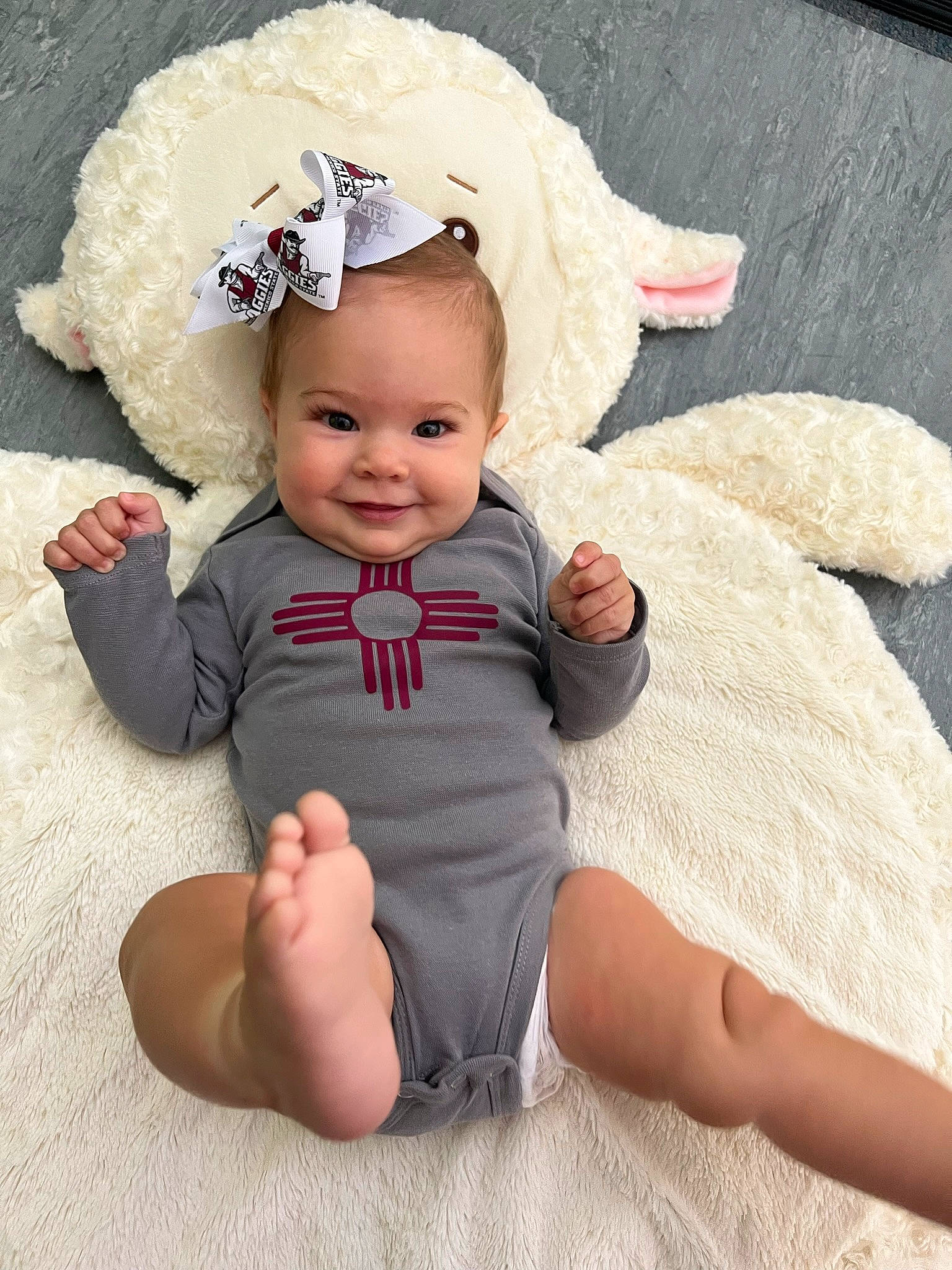 Grace is registered to the contest to win money with this photo: baby, baby_toddler_clothing, barefoot, child, comfort, costume_hat, fashion_accessory, foot, happy, head, headband, headgear, human_leg, joy, person, sitting, skin, sleeve, smile, textile