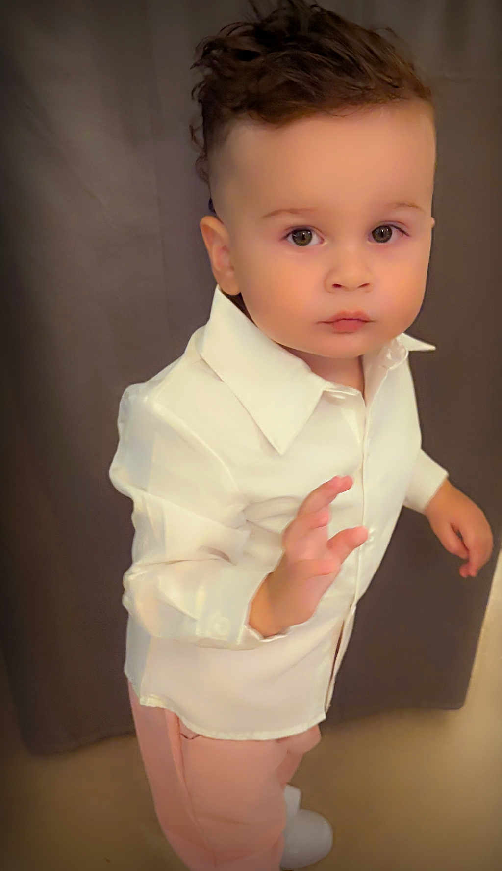 Dario participe au concours pour gagner de l'argent avec cette photo : toddler, child, person, face, hair, clothing, shirt, pants, footwear, standing, gesture, portrait, indoors, fashion, expression, cute, young, background, neutral, pose