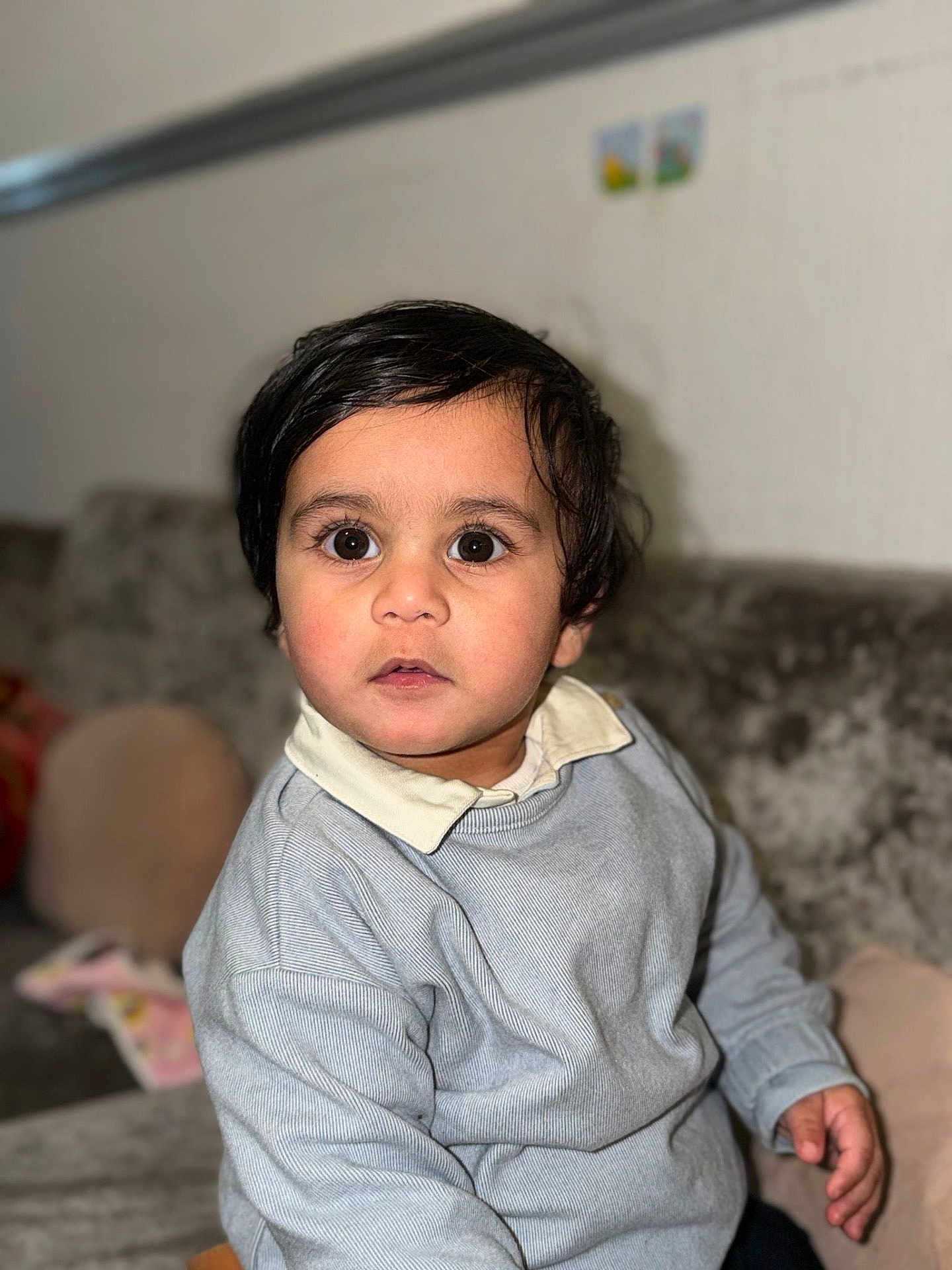 Ranfateh joined the competition — help win amazing prizes! toddler, child, face, portrait, indoors, couch, sweater, collared_shirt, curly_hair, big_eyes, person, young_child, seated, expression, looking_at_camera, home_interior, soft_lighting, casual_clothing, cute, skin