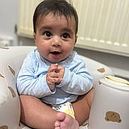 Ranfateh is registered to the contest to win money with this photo: baby, infant, child, diaper, blue_shirt, sitting, baby_chair, bear_pattern, foot, hands, curious_expression, indoors, radiator, soft_toys, cute, smiling, portrait, skin, young, cozy