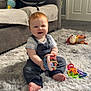 Leo joined the competition — help win amazing prizes! baby, child, smiling, toy, car_seat, sofa, blanket, rug, indoor, floor, red_hair, clothing, happy, playing, person, foot, carpet, living_room, cute, infant
