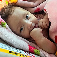 Jaylani joined the competition — help win amazing prizes! baby, blanket, child, closeup, comfort, cozy, curly_hair, cute, expression, eyes, face, fist, hand, indoors, infant, newborn, skin, soft_texture, warmth, wrapped