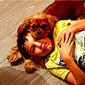 Douky participe au concours pour gagner de l'argent avec cette photo : boy, dog, floor, yellow_shirt, lying_down, pet, child, casual_clothing, brown_dog, wooden_floor, portrait, friendship, cute, cozy, relaxed, face, ears, indoor, comfort, playful