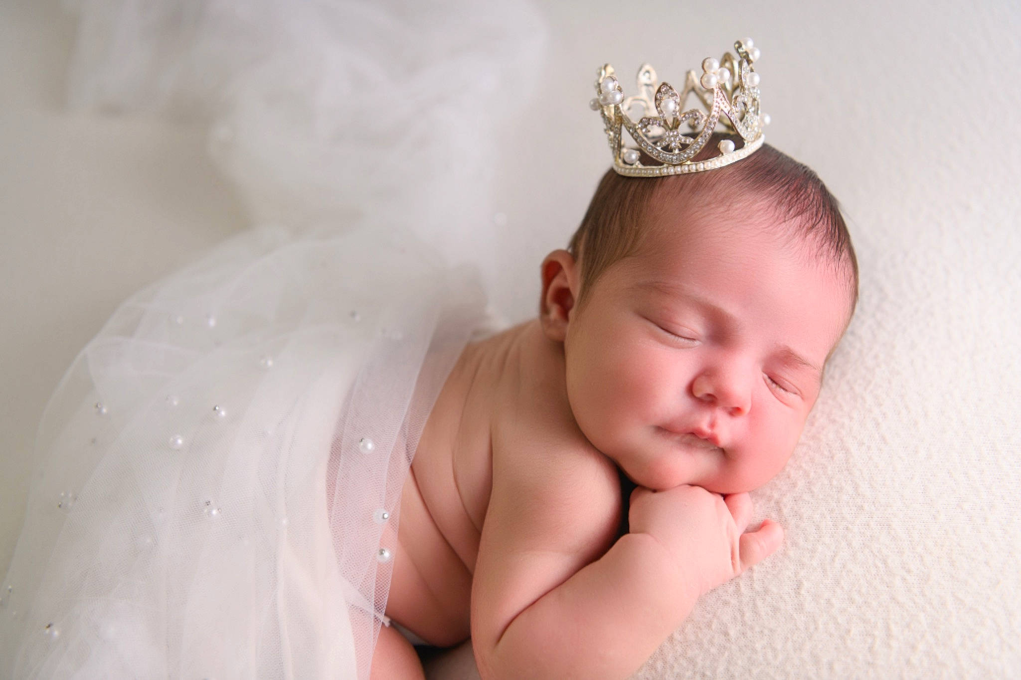 Ellie is registered to the contest to win money with this photo: baby, baby_toddler_clothing, blond, bridal_accessory, child, crown, ear, eyebrow, eyelash, finger, flash_photography, gesture, hand, happy, headband, headgear, headpiece, jewellery, person, tiara