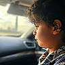 Muhammad is registered to the contest to win money with this photo: car_interior, casual_clothing, child, closeup, curly_hair, daylight, expression, indoors, passenger, person, portrait, profile, seat, seatbelt, side_view, soft_light, thoughtful, travel, window, young