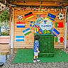 Muhammad joined the competition — help win amazing prizes! art_installation, blue_shirt, boy, child, colorful, curious, daylight, decorations, flags, globe_sculpture, green_carpet, kemah_texas, outdoor, paved_floor, playful, public_space, sneakers, soccer_balls, standing, wooden_pavilion