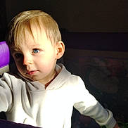 Aaron participe au concours pour gagner de l'argent avec cette photo : baby, blond_hair, blue_eyes, bright_light, child, colorful_toys, curious, cute, face, hand, indoor, light_and_shadow, person, playpen, portrait, soft_expression, toddler, toy, white_hoodie, young_child