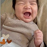 Kai is registered to the contest to win money with this photo: baby, smiling, laughing, infant, clothing, sweater, pants, hand, fist, happy, portrait, cute, joy, skin, face, hair, furniture, cozy, heart, lying_down