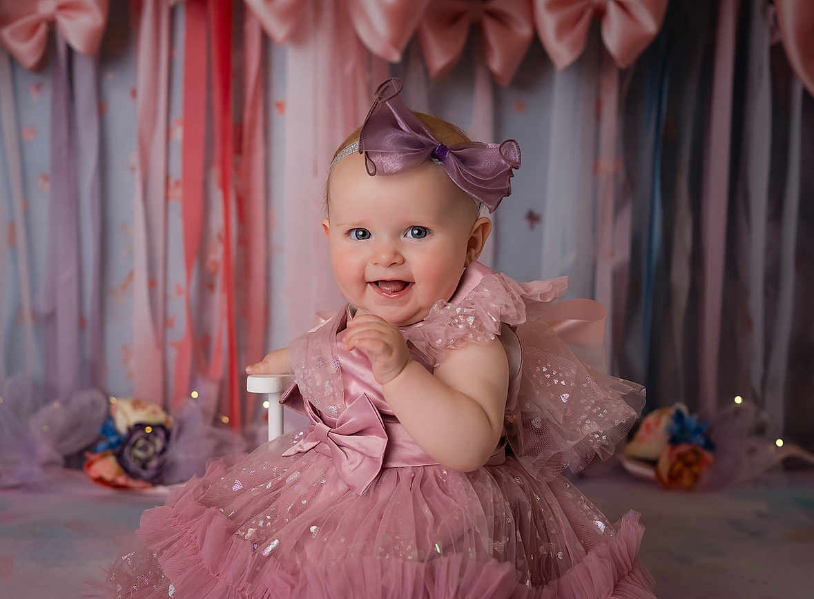 Charlee joined the competition — help win amazing prizes! baby, child, dress, pink, bow, headband, smile, happy, portrait, indoor, curtains, flowers, celebration, cute, tulle, ribbons, infant, sitting, decor, soft_lighting