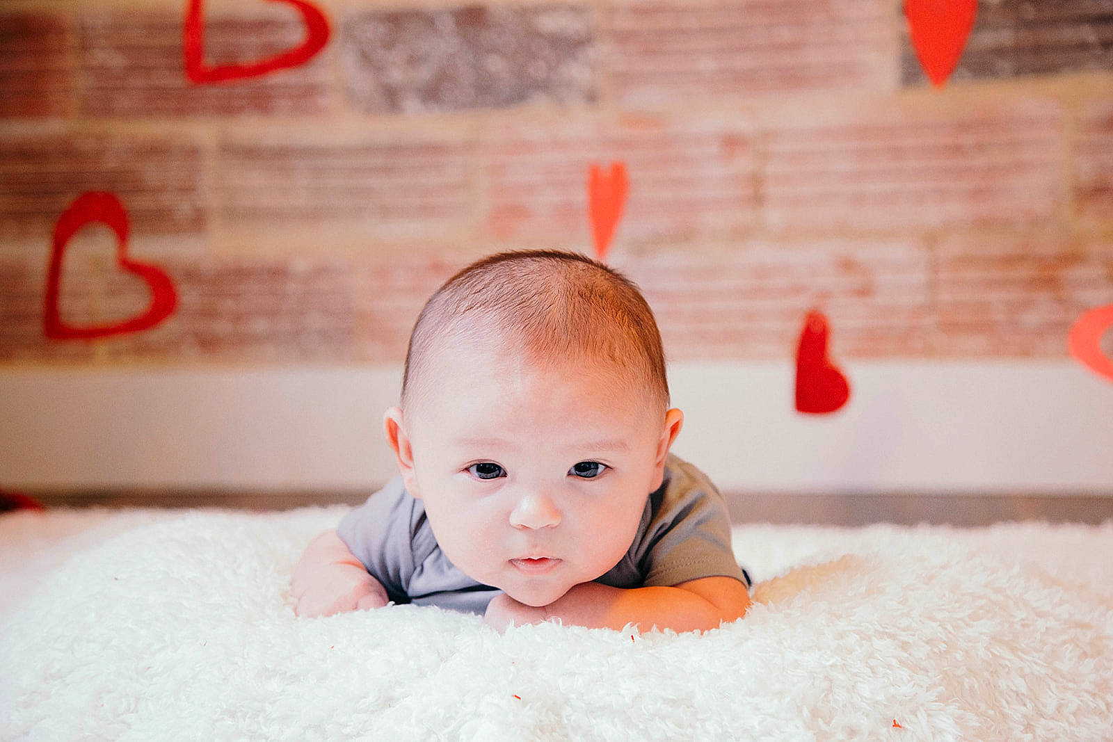 Jess is registered to the contest to win money with this photo: baby, baby_toddler_clothing, cheek, child, eye, eyebrow, eyelash, flash_photography, flooring, fun, grass, happy, iris, orange, person, red, sitting, smile, toddler, tummy_time