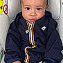baby, blazer, bodypart, car, car_interior, carseat, clothing, coat, cushion, face, finger, hand, head, homedecor, jacket, pants, person, photography, portrait, sitting