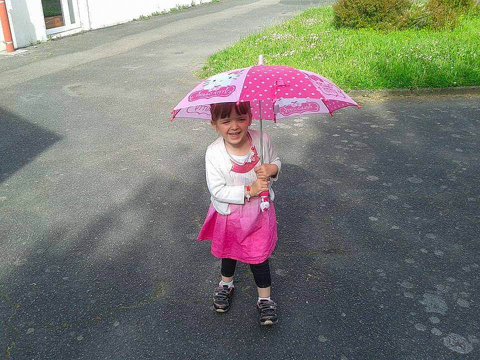 Léa Ch participe au concours pour gagner de l'argent avec cette photo : child, day, fun, girl, headwear, joy, person, pink, play, product, rain, recreation, toddler, umbrella, vacation