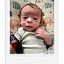 Elias is registered to the contest to win money with this photo: baby, newborn, infant, face, expression, blanket, elephant_pattern, clothing, hand, portrait, indoors, cute, young_child, lying_down, soft_toys, close_up, skin, head, small_hands, resting