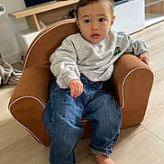 Sacha Leroux a rejoint le concours — aidez-le/la à gagner de superbes lots ! armchair, barefoot, casual_wear, child, clothing, curious, cute, expression, floor, furniture, home, indoor, jeans, living_room, person, relaxed, seated, sweatshirt, toddler, young_child