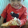 Jolie is registered to the contest to win money with this photo: toddler, child, pizza, smiling, red_sweater, curly_hair, food, happy, sitting, indoors, bed, blanket, cute, portrait, eating, cheese_pizza, clothing, person, young_child, casual