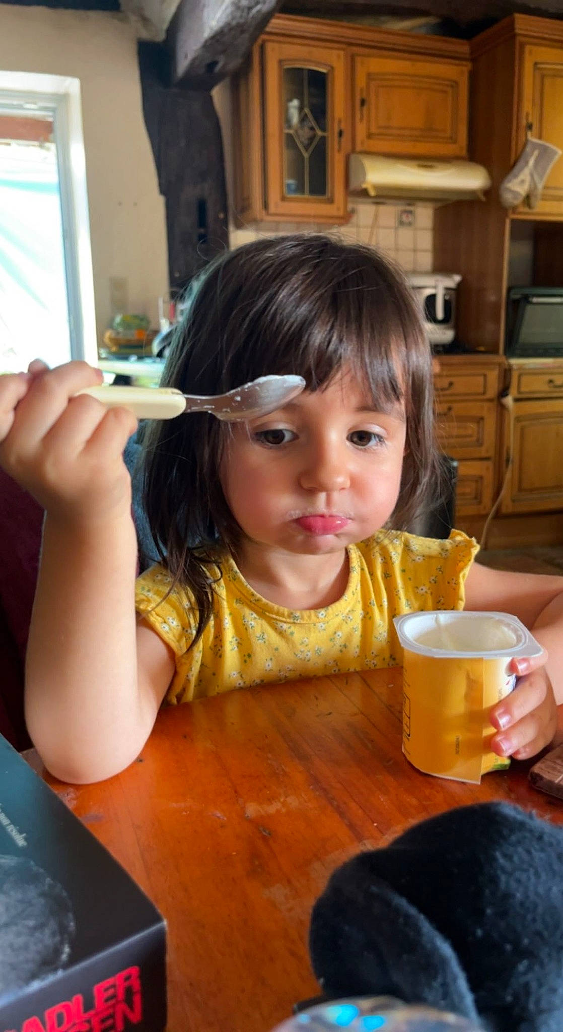 Océane participe au concours pour gagner de l'argent avec cette photo : cabinetry, chair, child, coffee_cup, cup, cupboard, desk, drinkware, flooring, food, home_appliance, kitchen_appliance, person, plate, sharing, sitting, soft_drink, table, tableware, toddler