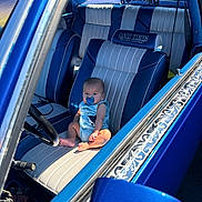 Haziel is registered to the contest to win money with this photo: baby, pacifier, car, vintage_car, blue, leather_seat, steering_wheel, interior, child, sunlight, window, door, seat, infant, sitting, curious, automobile, classic_car, people, portrait