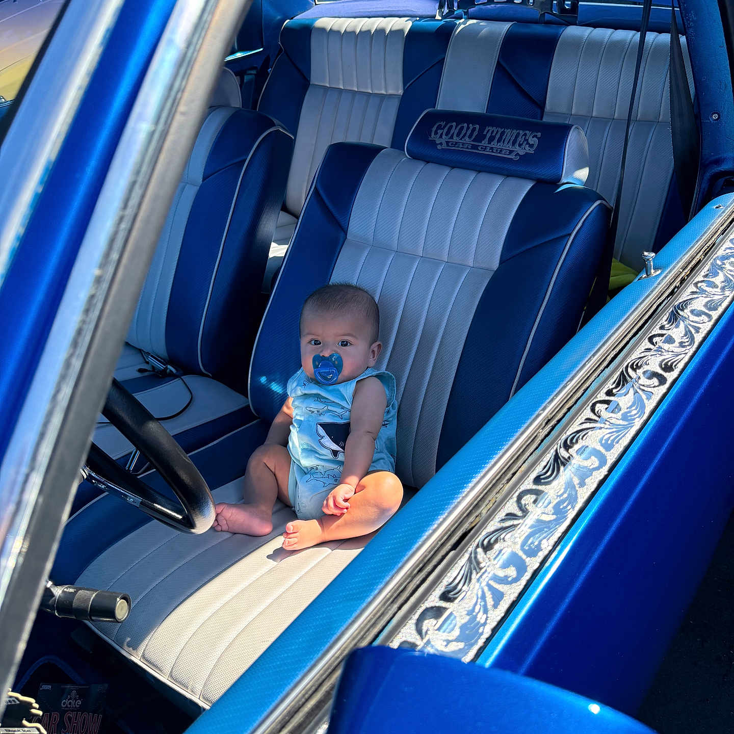 Haziel is registered to the contest to win money with this photo: automobile, baby, blue, car, child, classic_car, curious, door, infant, interior, leather_seat, pacifier, people, portrait, seat, sitting, steering_wheel, sunlight, vintage_car, window