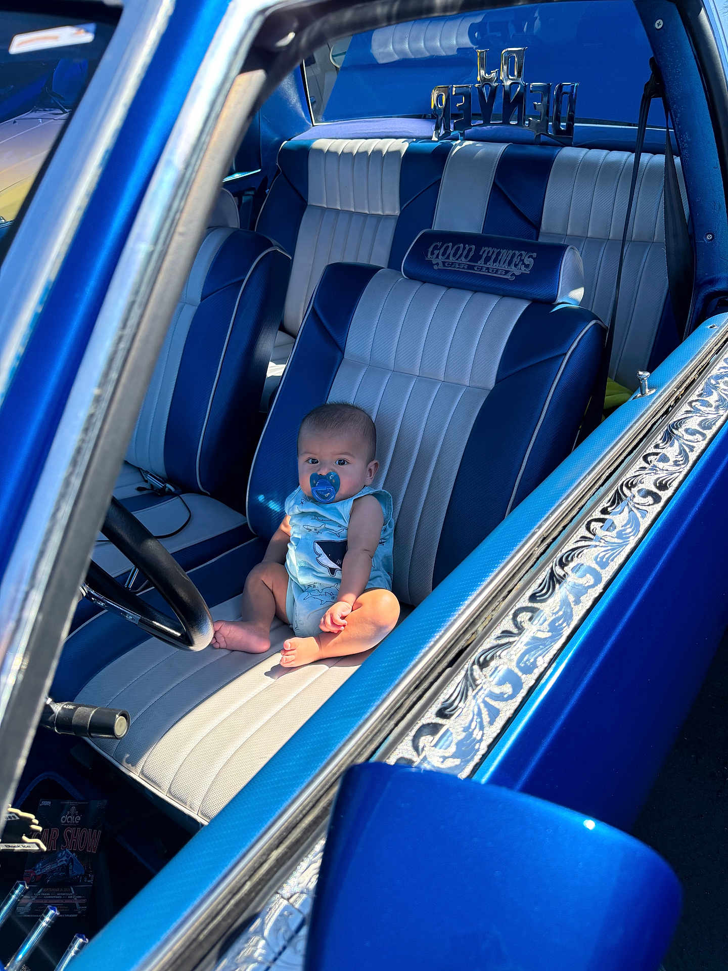 Haziel is registered to the contest to win money with this photo: baby, pacifier, car, vintage_car, blue, leather_seat, steering_wheel, interior, child, sunlight, window, door, seat, infant, sitting, curious, automobile, classic_car, people, portrait