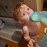 toddler, child, baby, bottle, drinking, wet_hair, barefoot, bathroom, floor, rug, wooden_floor, blue_bottle, looking_up, indoors, diaper, person, curious, young_child, bathmat, home