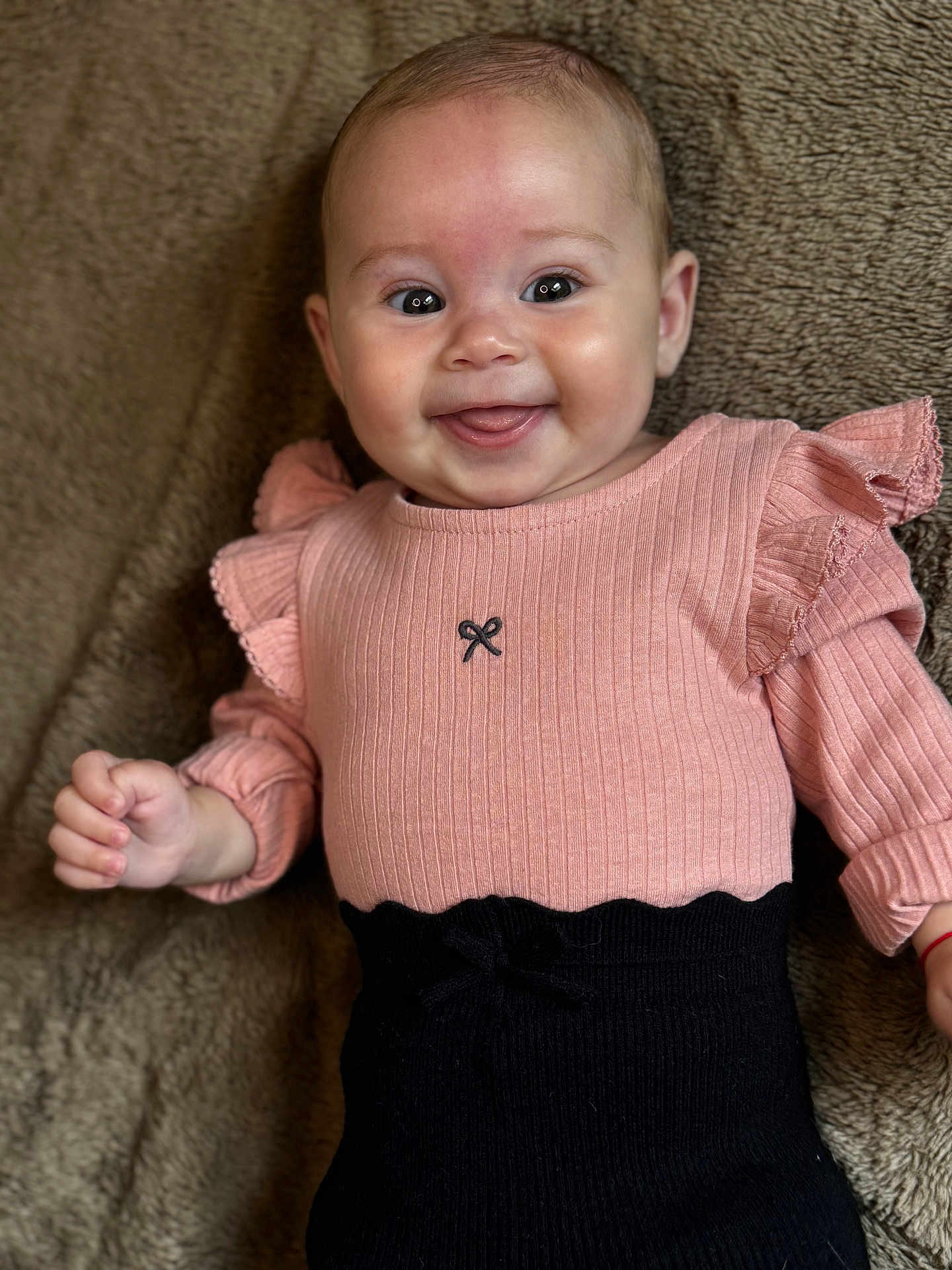 Haïvie participe au concours pour gagner de l'argent avec cette photo : baby, smiling, infant, pink_clothing, black_clothing, happy, tongue_out, cute, lying_down, blanket, texture, face, portrait, child, young, human, skin, eyes, hands, apparel