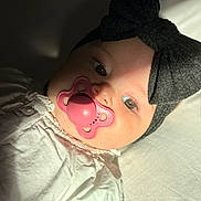 Haïvie a rejoint le concours — aidez-le/la à gagner de superbes lots ! baby, black_bow, child, closeup, cute, expression, eyes, face, headband, indoors, infant, newborn, pacifier, portrait, shadow, skin, sleeping_area, soft_light, toddler, white_clothing