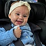 baby, blue_sweater, bow, car_interior, car_seat, child, closeup, clothing, cute, face, hand, happy, headband, indoors, infant, pacifier, person, safety, seatbelt, smiling