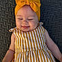 apparel, baby, child, closeup, cute, fashion, happy, headband, headwear, infant, joy, mat, outdoor, person, portrait, smiling, striped_dress, texture, yellow, young_child