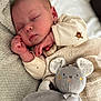 newborn, baby, sleeping, plush_toy, mouse, blanket, soft_texture, cozy, infant, cute, peaceful, cream_clothing, face, hand, bed, rest, child, sleep, comfort, fabric