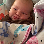 Oakley is registered to the contest to win money with this photo: baby, infant, blanket, pattern, animal_print, face, expression, cushion, clothing, indoors, person, portrait, cute, resting, cozy, head, skin, newborn, child, soft