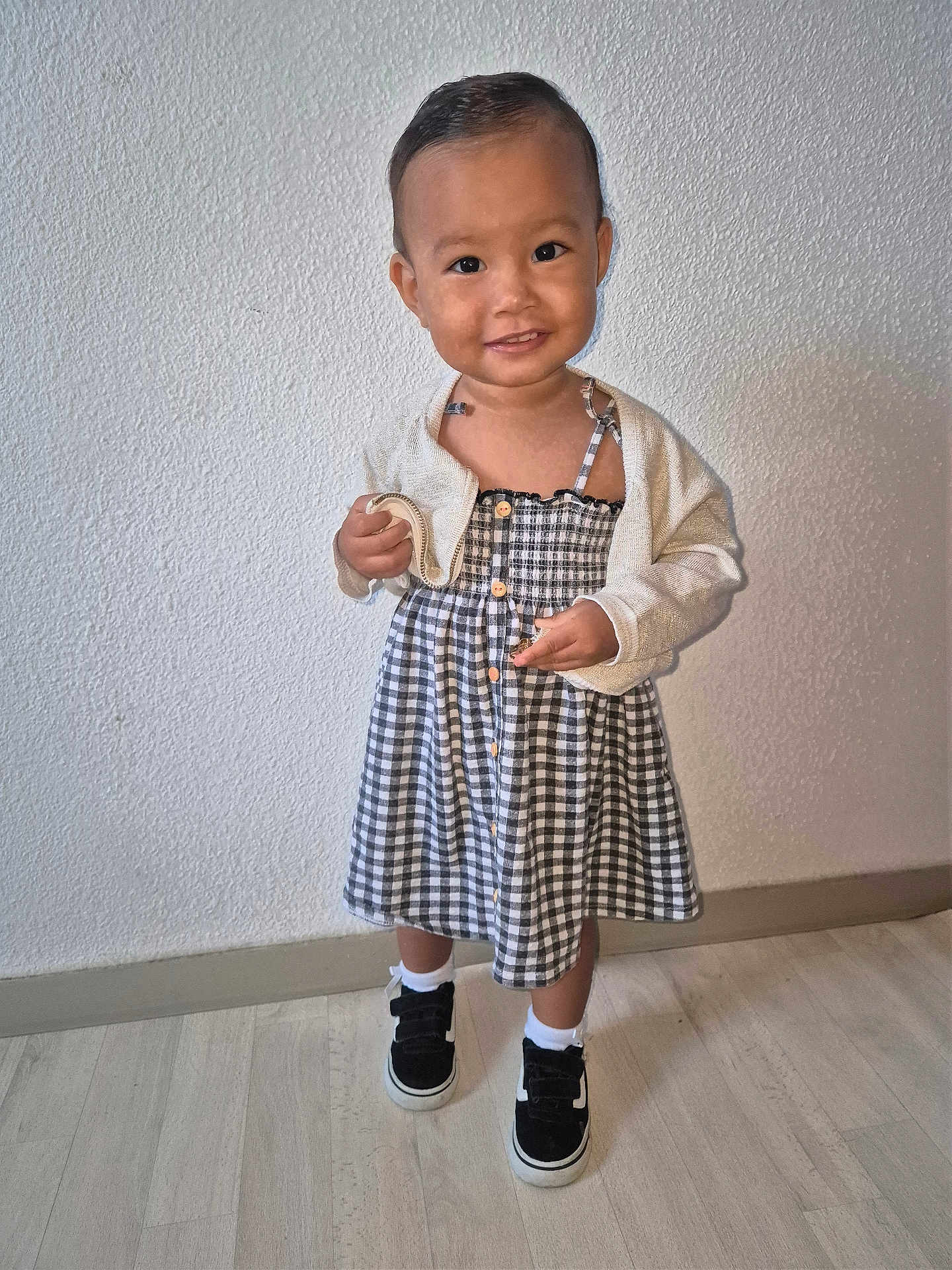 Nellya participe au concours pour gagner de l'argent avec cette photo : toddler, child, smile, dress, cardigan, shoes, socks, floor, wall, indoor, person, portrait, standing, happy, cute, young, clothing, footwear, hair, skin