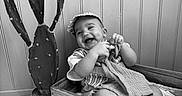 Eden participe au concours pour gagner de l'argent avec cette photo : baby, smiling, cap, crate, wooden_crate, cactus, plant, indoor, blanket, cloth, child, happy, monochrome, black_and_white, floor, wall, pot, sitting, cute, portrait