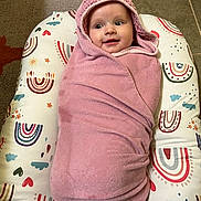 Kaliana is registered to the contest to win money with this photo: baby, blanket, bonnet, cap, clothing, face, furniture, hat, head, hood, hosiery, newborn, person, photography, portrait, purple, quilt, sock, standing, towel