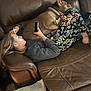 Mr. Beef is registered to the contest to win money with this photo: person, dog, couch, leather, phone, pajama_pants, floral_pattern, relaxing, indoor, casual, pet, companion, brown, comfort, home, resting, cozy, sleeping_dog, human, lifestyle