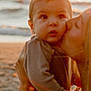 affection, baby, beach, closeup, clothing, emotion, family, holding, kiss, love, nature, outdoor, person, portrait, sand, sea, sunset, warm_light, water, woman