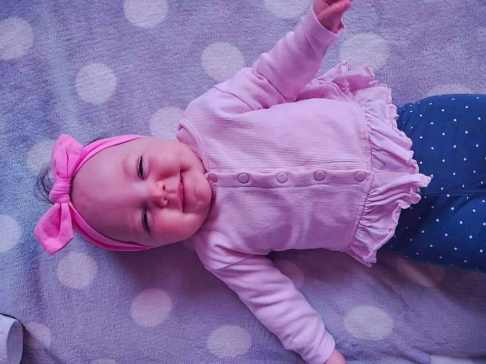 Inaya a rejoint le concours — aidez-le/la à gagner de superbes lots ! baby, baby_products, baby_toddler_clothing, cheek, child, comfort, grass, human_body, human_leg, linens, magenta, pattern, person, pink, purple, room, sitting, skin, sleeve, toddler