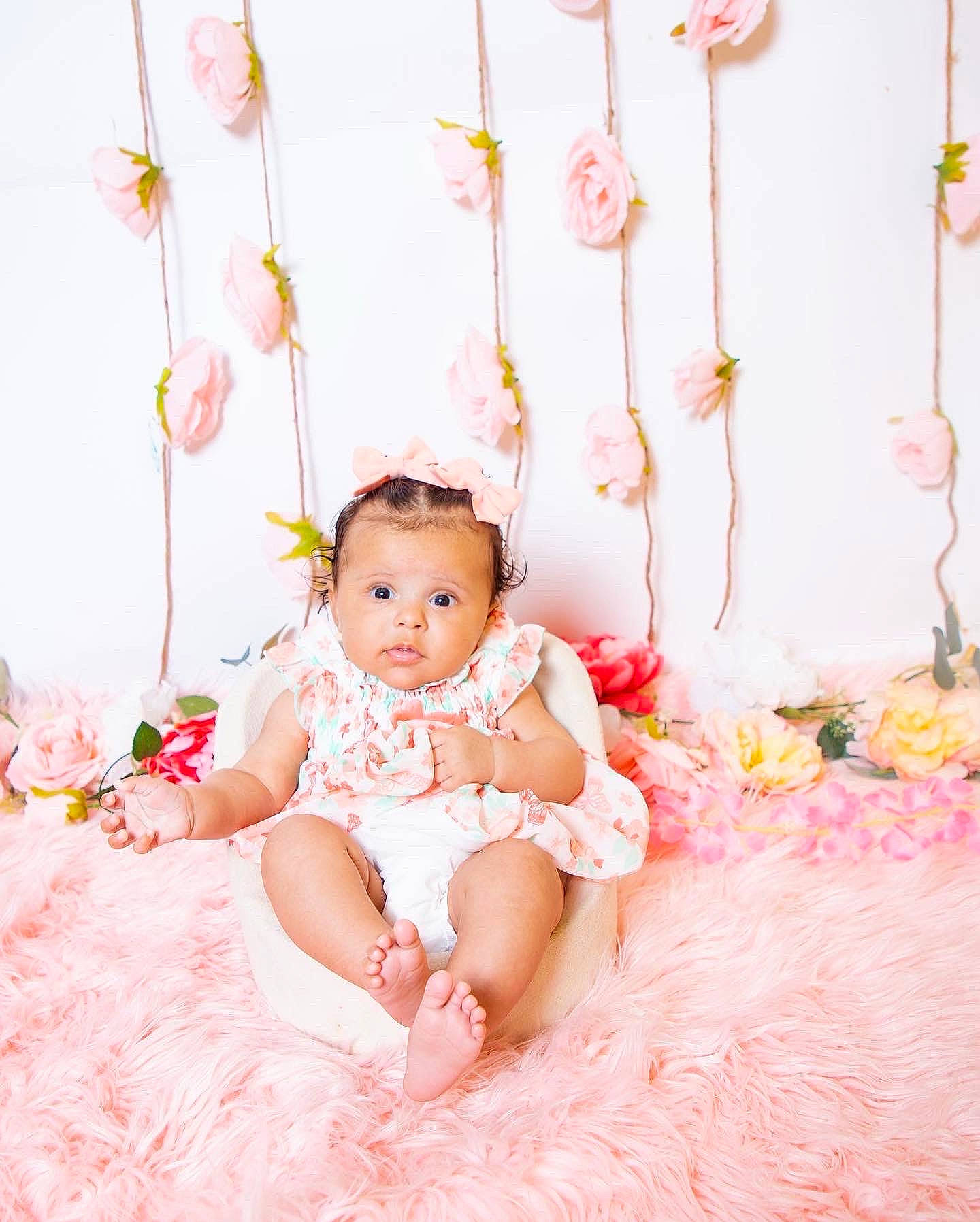 Evee is registered to the contest to win money with this photo: baby, baby_toddler_clothing, comfort, dress, embellishment, event, hair_accessory, happy, head, headpiece, linens, magenta, pattern, peach, person, petal, pink, sitting, sleeve, textile