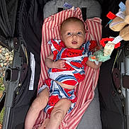 Indy joined the competition — help win amazing prizes! baby, infant, stroller, blanket, striped_blanket, toy, colorful_clothing, watermelon_pattern, outdoor, legs, face, hand, soft_toy, fabric, comfort, cute, child, person, resting, casual