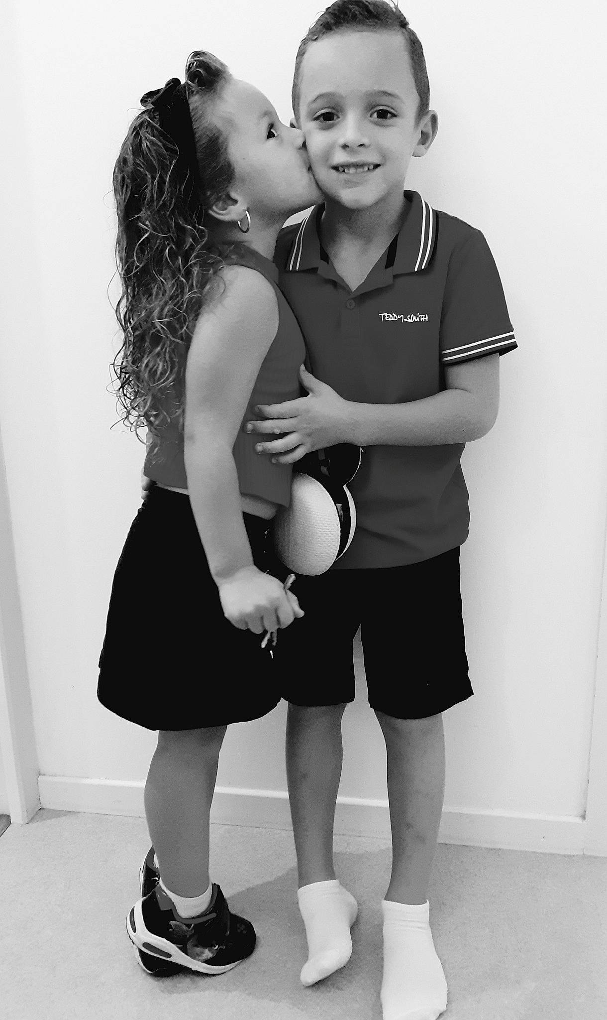 Nessy participe au concours pour gagner de l'argent avec cette photo : black, black_and_white, child, dress, face, footwear, happy, interaction, joint, joy, leg, monochrome, monochrome_photography, person, photograph, photography, shoulder, smile, snapshot, standing