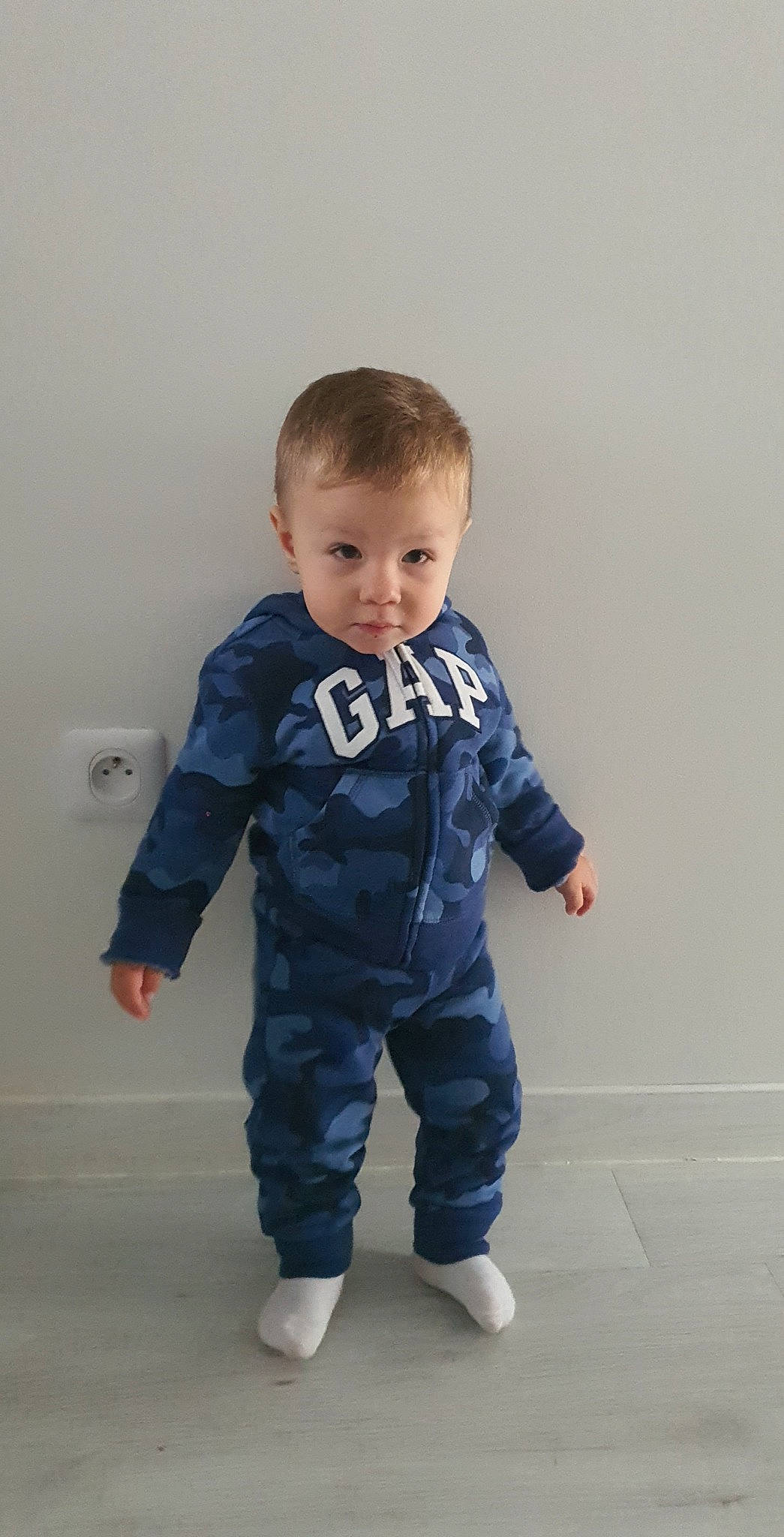 Kaan participe au concours pour gagner de l'argent avec cette photo : baby, baby_toddler_clothing, barefoot, child, electric_blue, eye, face, flooring, fun, hairstyle, happy, knee, leg, pattern, person, sitting, skin, sleeve, smile, t_shirt