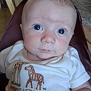 Edgerrin joined the competition — help win amazing prizes! baby, infant, face, eyes, onesie, clothing, giraffe, zebra, embroidery, text, cute, child, portrait, skin, head, expression, indoor, person, newborn, babywear