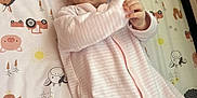 Rosalyn is registered to the contest to win money with this photo: baby, infant, onesie, pink_clothing, lying_down, animal_pattern, blanket, cute, child, face, hands, playful, indoor, portrait, young_child, smiling, soft_lighting, bed, sleepwear, cozy