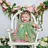 baby, child, smile, green_dress, flower_crown, white_chair, flowers, floral_arrangement, pink_flowers, white_flowers, plant, nature, portrait, cute, happy, sitting, indoor, decor, person, baby_dress