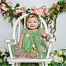 baby, child, green_dress, floral_crown, white_chair, flowers, pink_flowers, white_flowers, greenery, smiling, sitting, portrait, innocence, happy, cute, decor, background, nature, toddler, studio_photo