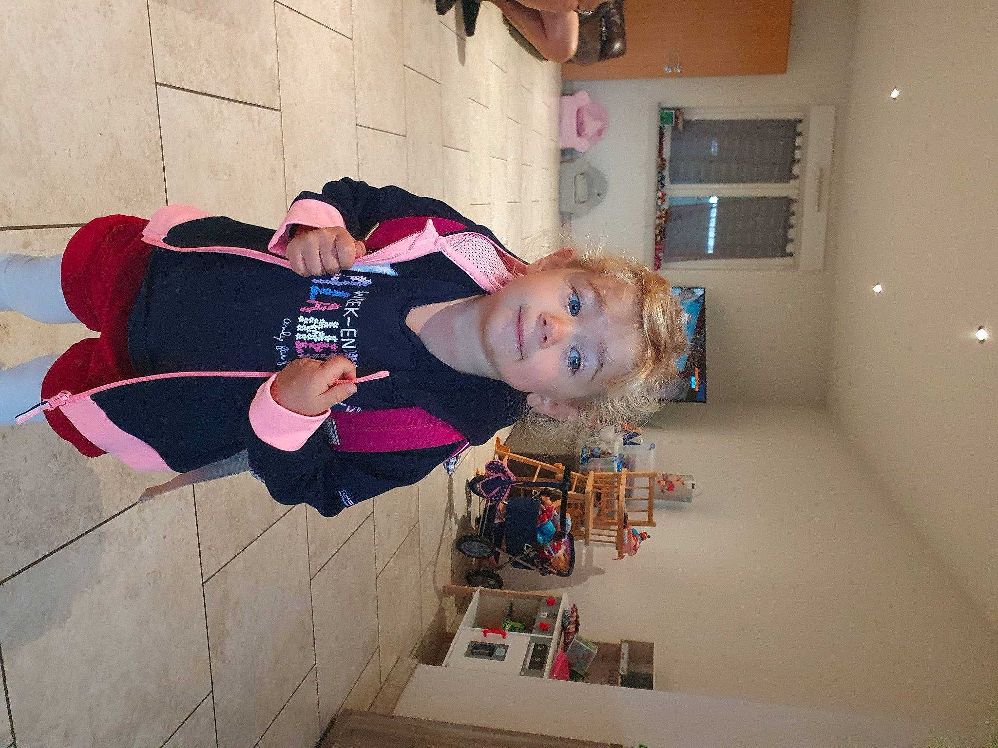 Louise participe au concours pour gagner de l'argent avec cette photo : baby, carmine, child, door, flooring, fun, happy, house, magenta, person, picture_frame, pink, room, shelf, smile, toddler, window, wood