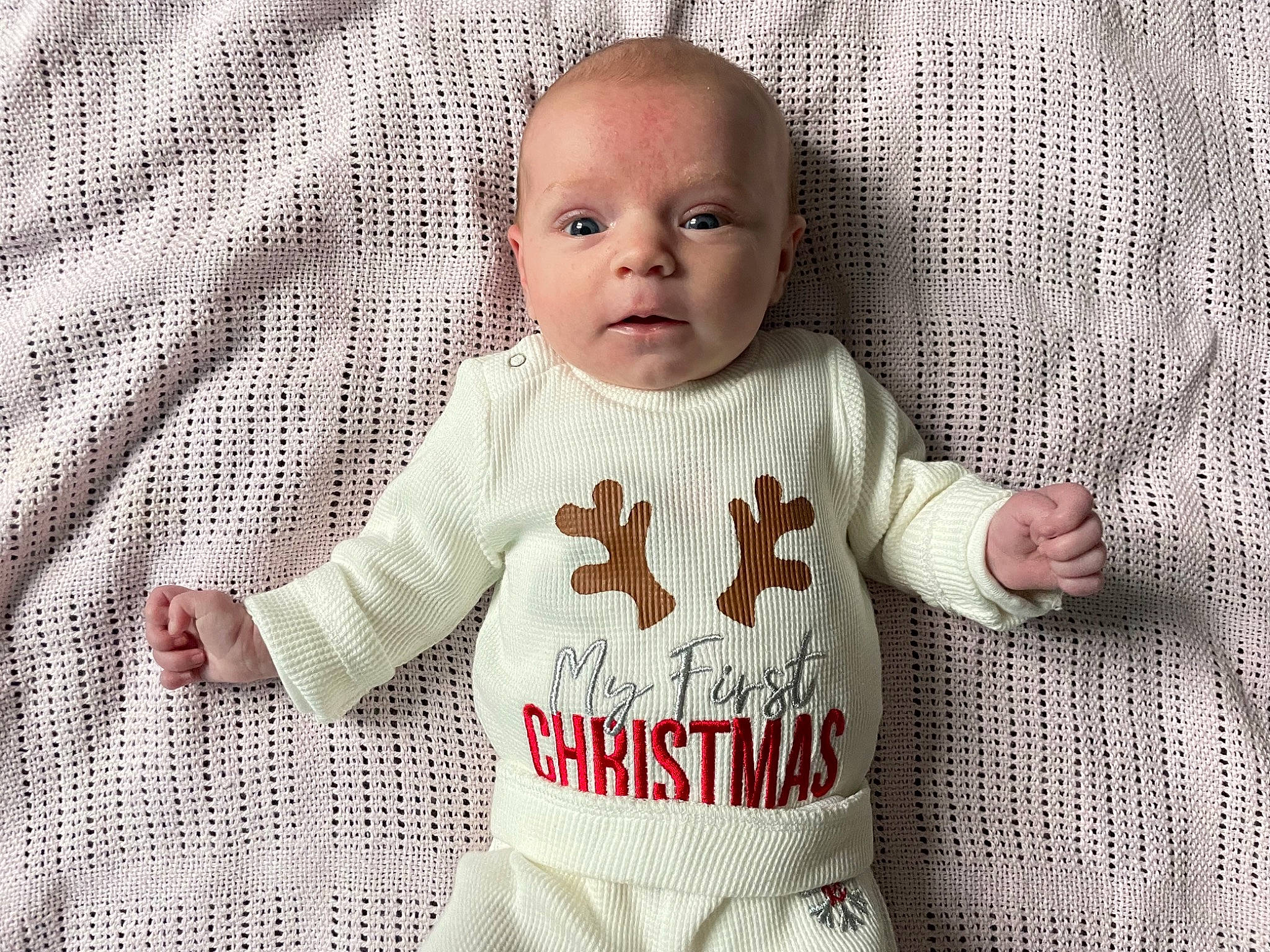 Ellie is registered to the contest to win money with this photo: baby, baby_toddler_clothing, comfort, facial_expression, finger, gesture, grey, hand, happy, head, jersey, mammal, outerwear, person, product, skin, sleeve, smile, standing, t_shirt