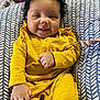 baby, babylaughing, bodypart, clothing, coat, couch, cushion, face, finger, furniture, hand, happy, head, homedecor, pants, person, photography, portrait, sitting, smile