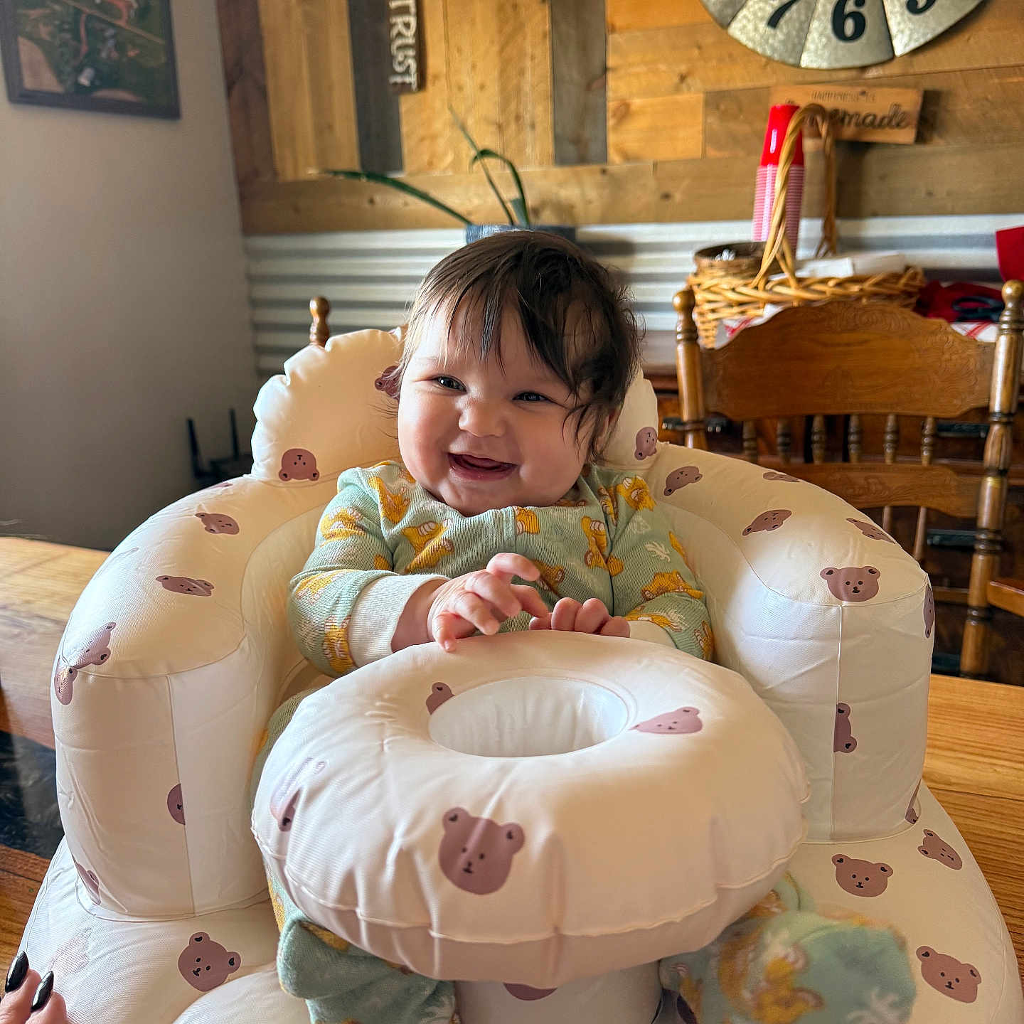 Aerlynn is registered to the contest to win money with this photo: baby, bear_pattern, child, clock, cozy, cute, footwear, furniture, hand, happy, homedecor, indoor, inflatable_chair, onesie, person, plant, seated, smiling, table, wooden_wall