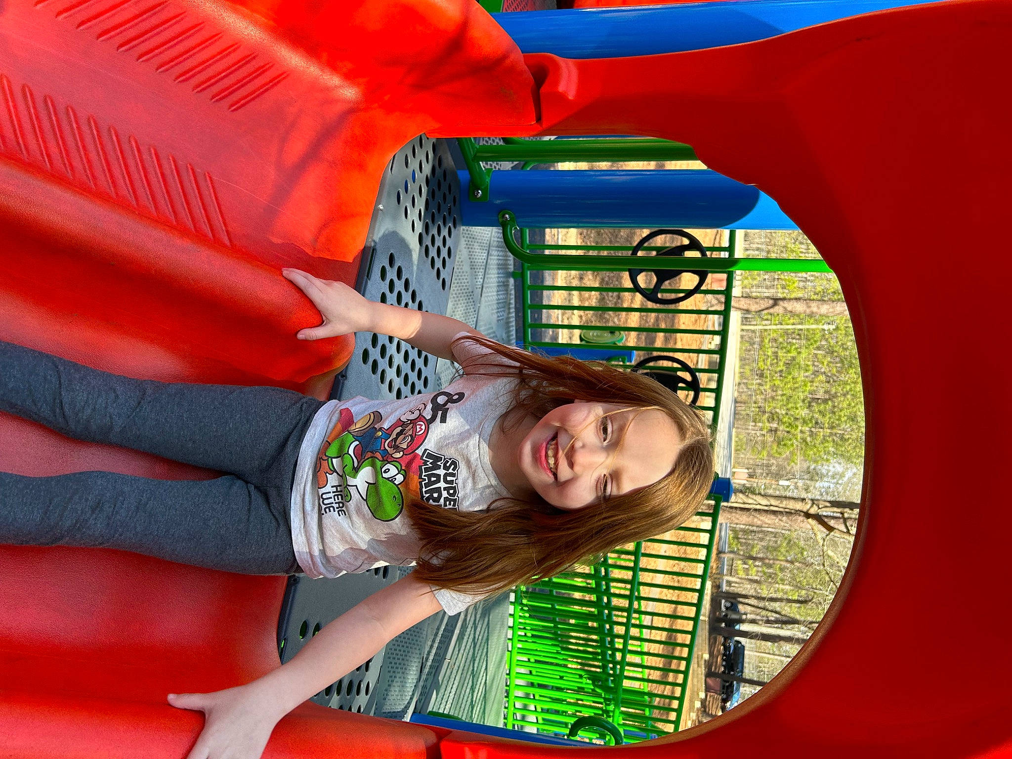 Piper is registered to the contest to win money with this photo: bounce_house, child, chute, city, fun, grass, happy, joy, leisure, organ, outdoor_play_equipment, person, photograph, play, playground, playground_slide, recreation, red, snapshot, thigh