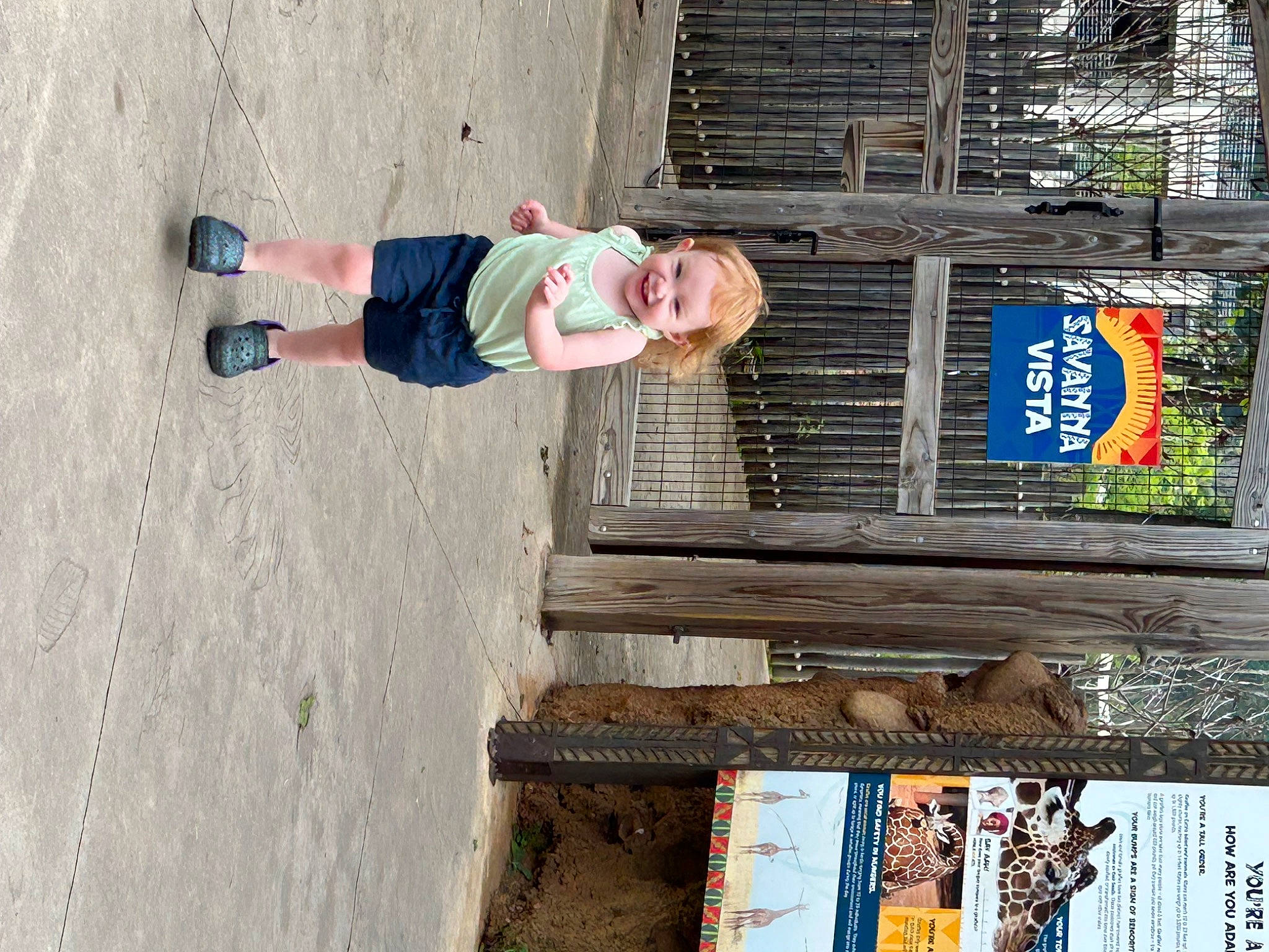 Lucy is registered to the contest to win money with this photo: composite_material, concrete, denim, joy, line, outdoor_shoe, person, smile, toddler, walking_shoe, wall, wood